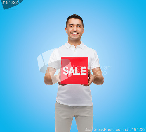 Image of smiling man with red sale sigh