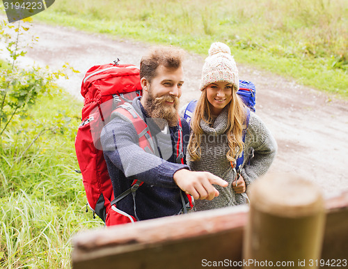 Image of smiling couple with backpacks hiking