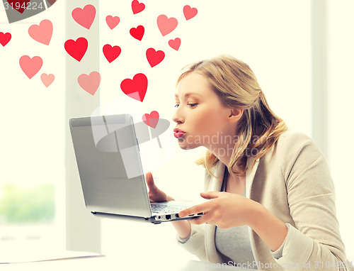 Image of woman sending kisses with laptop computer