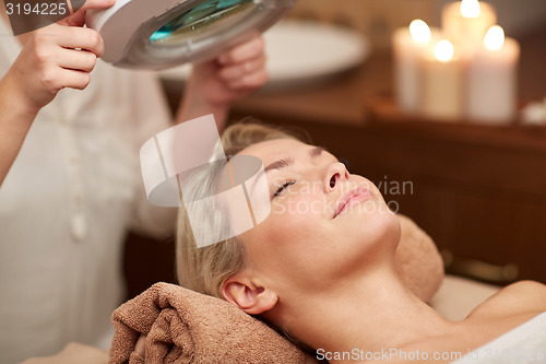 Image of close up of young woman lying in spa