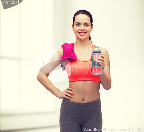 Image of sporty woman with towel and water bottle