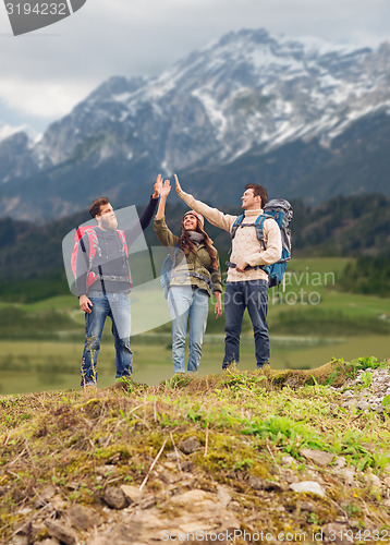 Image of group of smiling friends with backpacks hiking