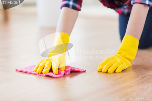 Image of close up of woman with rag cleaning floor at home