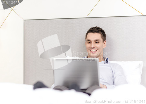 Image of happy businesswoman with laptop in hotel room