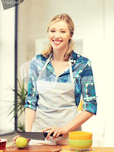 Image of beautiful woman in the kitchen cutting an apple