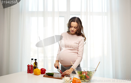 Image of pregnant woman preparing food at home