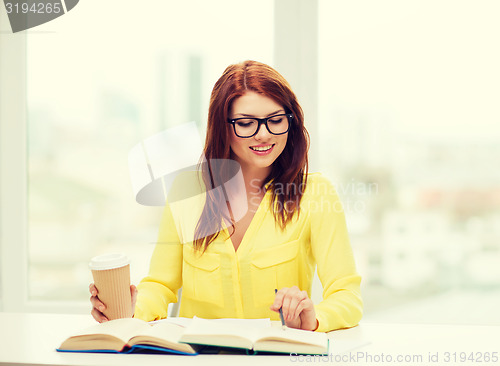 Image of smiling student girl reading books in library