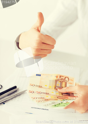 Image of woman hands with euro cash money and thumbs up