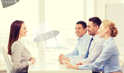 Image of smiling businesswoman at interview in office