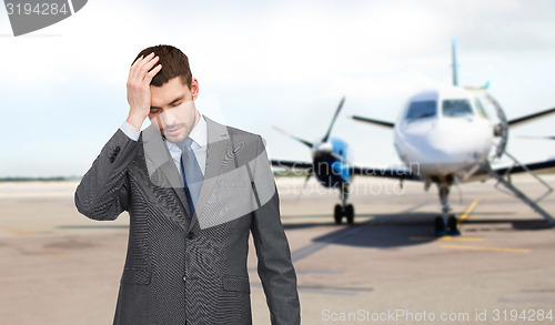 Image of businessman over airplane on runway background