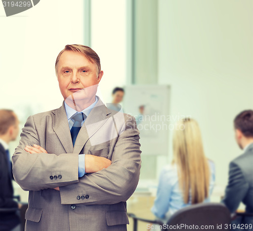 Image of serious businessman or teacher in suit at office