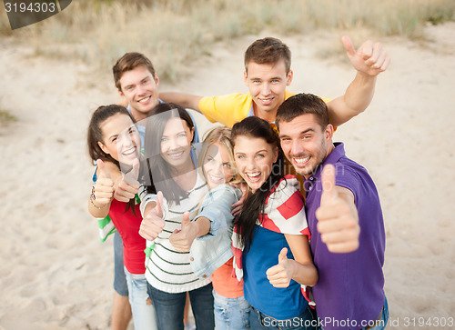 Image of group of happy friends having fun on beach