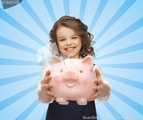 Image of happy girl holding piggy bank 