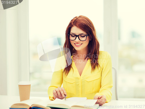 Image of smiling student girl reading books in library