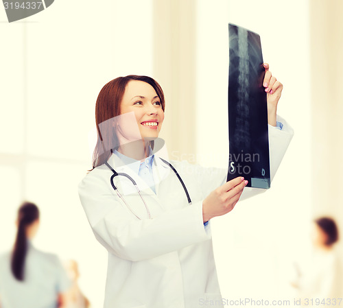 Image of smiling female doctor looking at x-ray