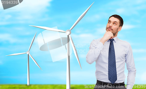 Image of handsome businessman looking up