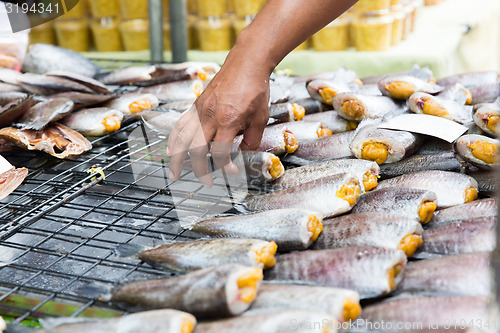 Image of close up of hand taking fish at street market