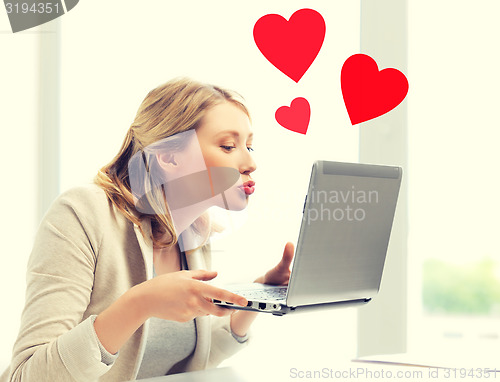Image of woman sending kisses with laptop computer