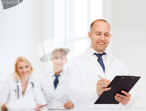 Image of smiling male doctor with clipboard