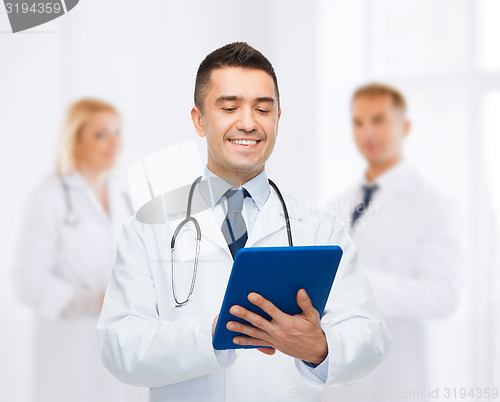 Image of smiling male doctor with tablet pc at hospital