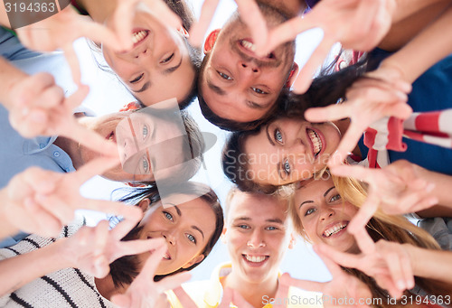 Image of smiling friends in circle on summer beach