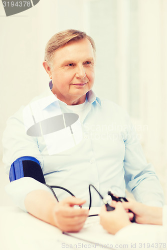 Image of female doctor or nurse measuring blood pressure