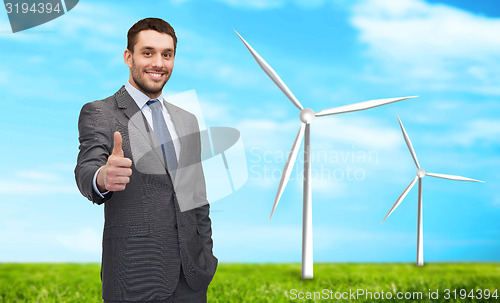 Image of handsome businessman showing thumbs up