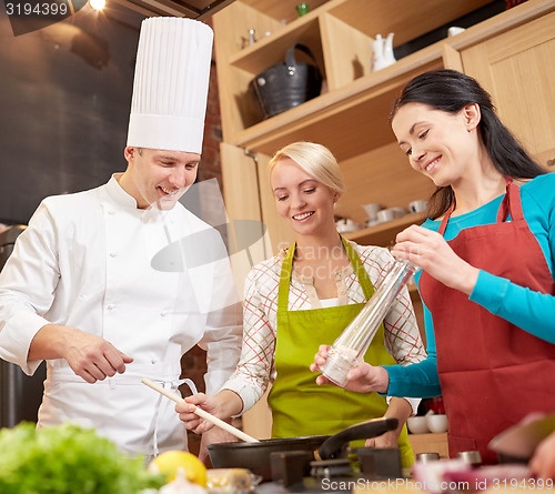 Image of happy women and chef cook cooking in kitchen