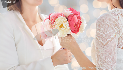 Image of close up of happy lesbian couple with flowers