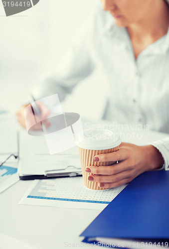 Image of woman with coffee filling in blank paper