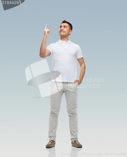 Image of smiling man pointing finger up