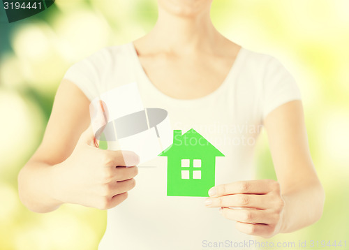 Image of woman hands holding green house