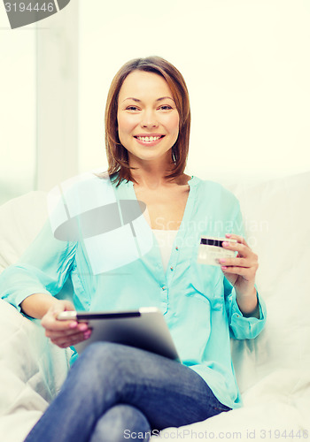 Image of smiling woman with tablet pc computer at home