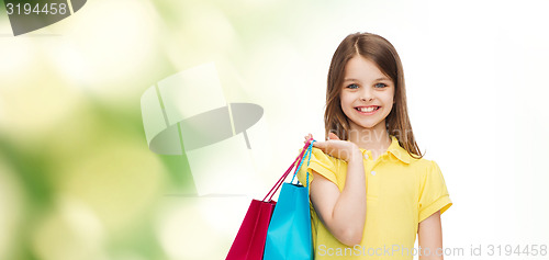 Image of smiling little girl in dress with shopping bags