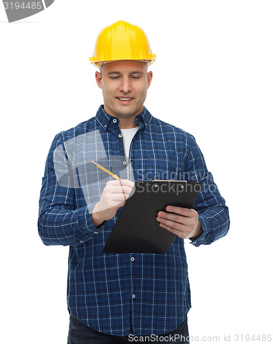 Image of smiling male builder in helmet with clipboard