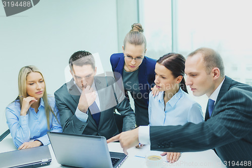 Image of business team with laptop having discussion