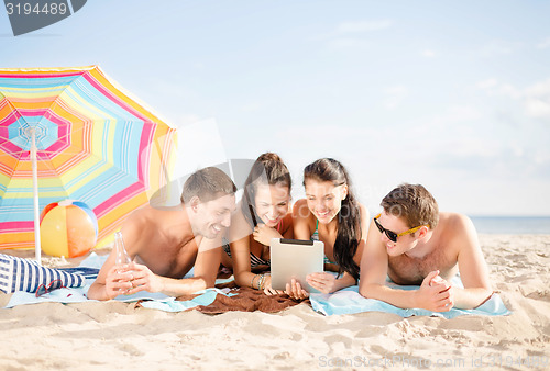 Image of happy friends with tablet pc on beach