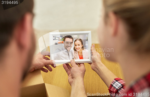 Image of close up of happy couple looking at family photo