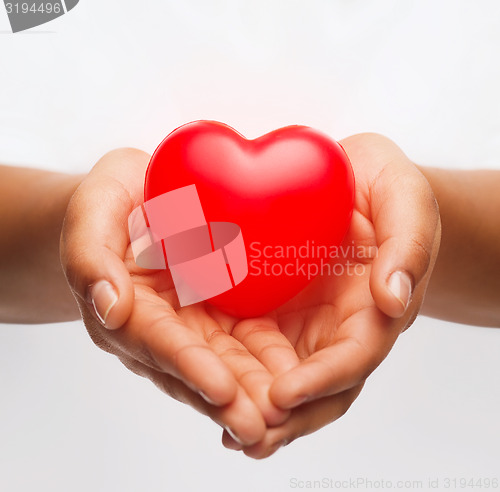 Image of female hands with small red heart