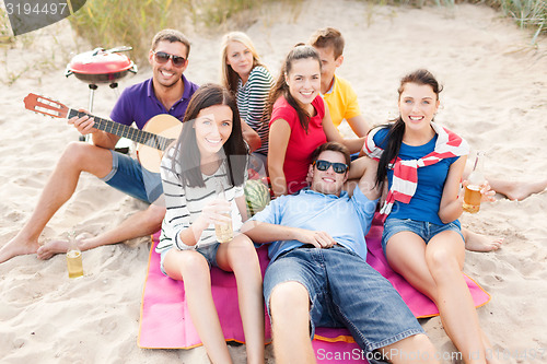 Image of group of happy friends having fun on beach