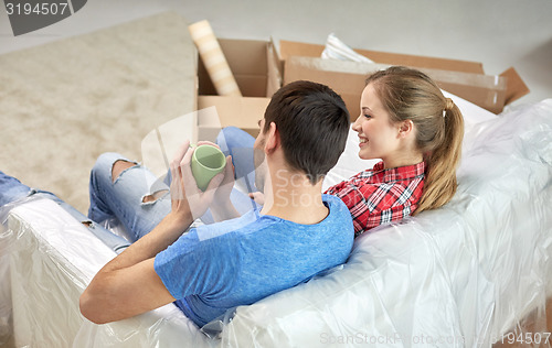 Image of happy couple relaxing on sofa in new home