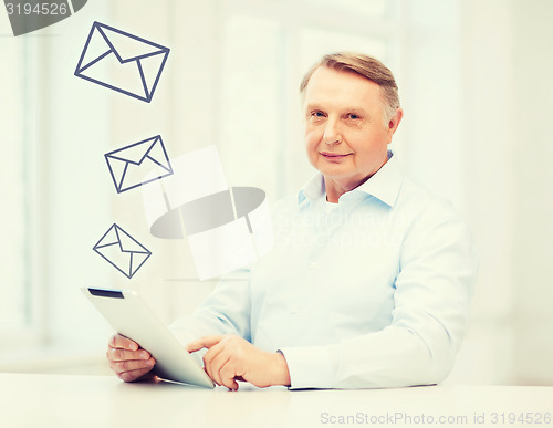 Image of old man with tablet computer at home