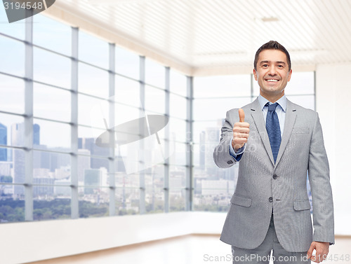 Image of happy businessman in suit showing thumbs up