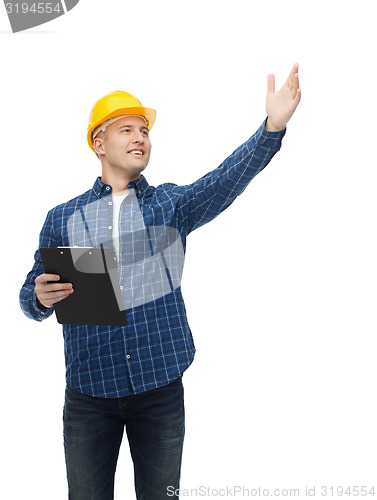 Image of smiling male builder in helmet with clipboard