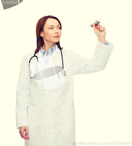 Image of young female doctor writing something in the air