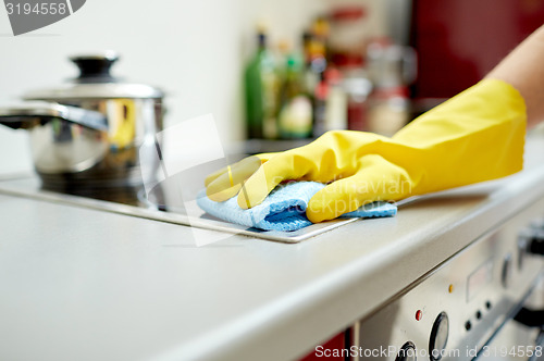 Image of close up of woman cleaning cooker at home kitchen