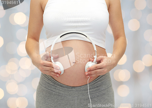 Image of close up of pregnant woman and headphones on tummy