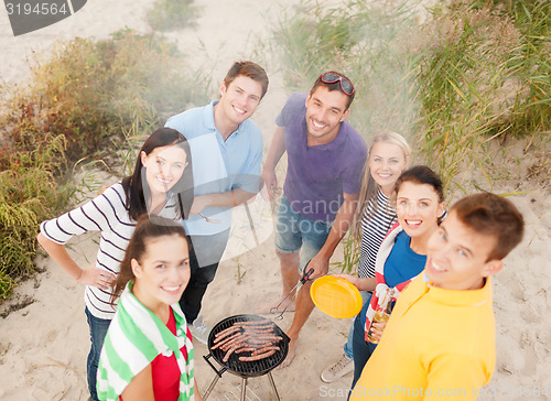 Image of group of friends having picnic on beach