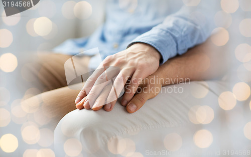 Image of close up of happy male gay couple holding hands