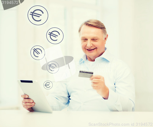 Image of old man with tablet pc and credit card at home